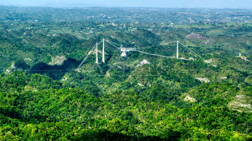 Arecibo Observatory rising above the lush green Karst Forest, Puerto Rico Aerial Stock Photo AX101_087.0000000F | Axiom Images